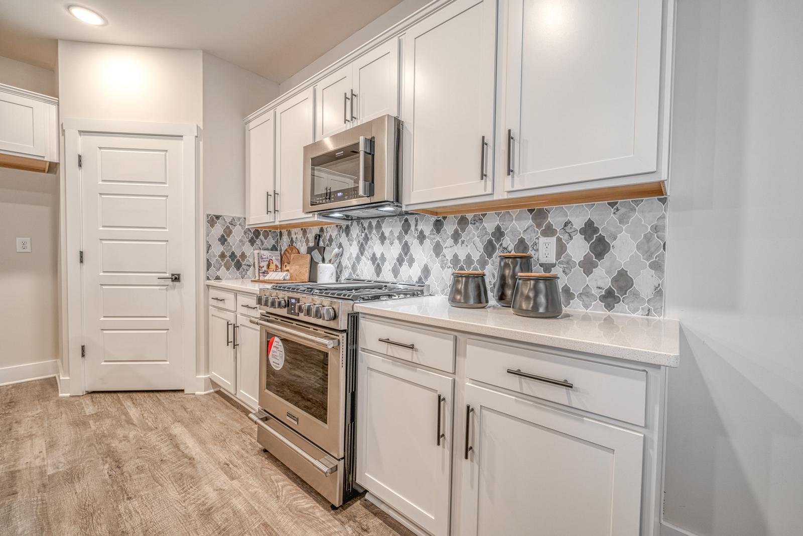 Allston modern kitchen with island, white cabinets, pendant lights, and premium finishes