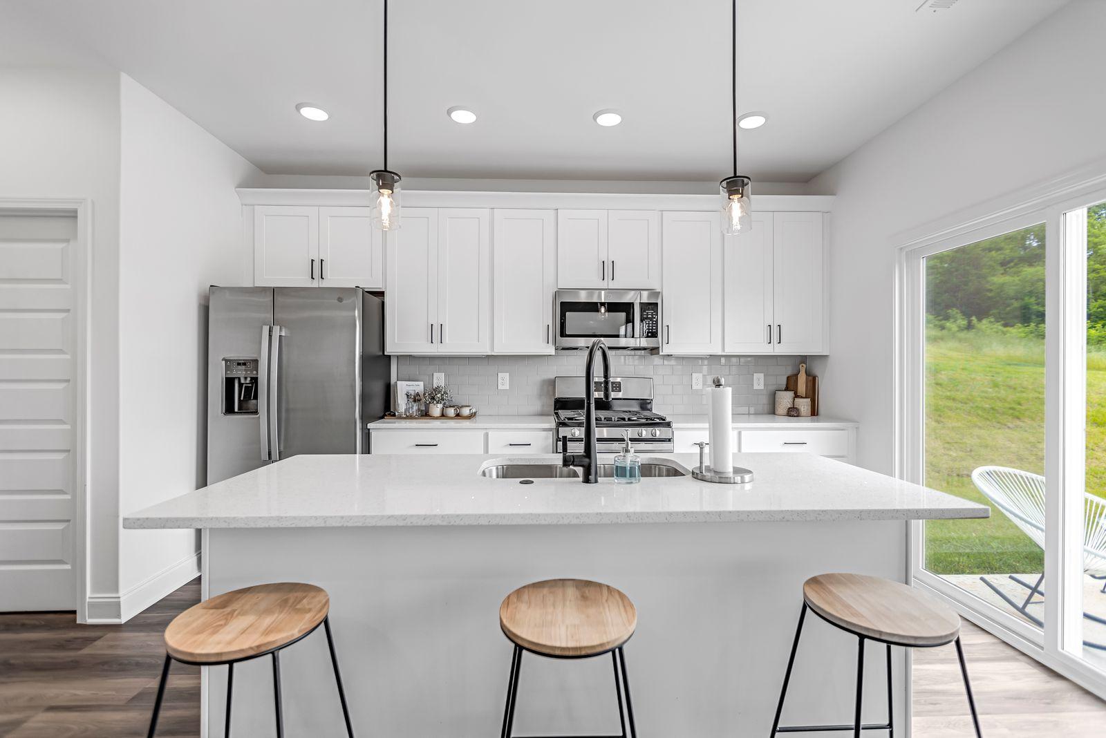 Amber Vista modern kitchen with island, white cabinets, pendant lights, and premium finishes