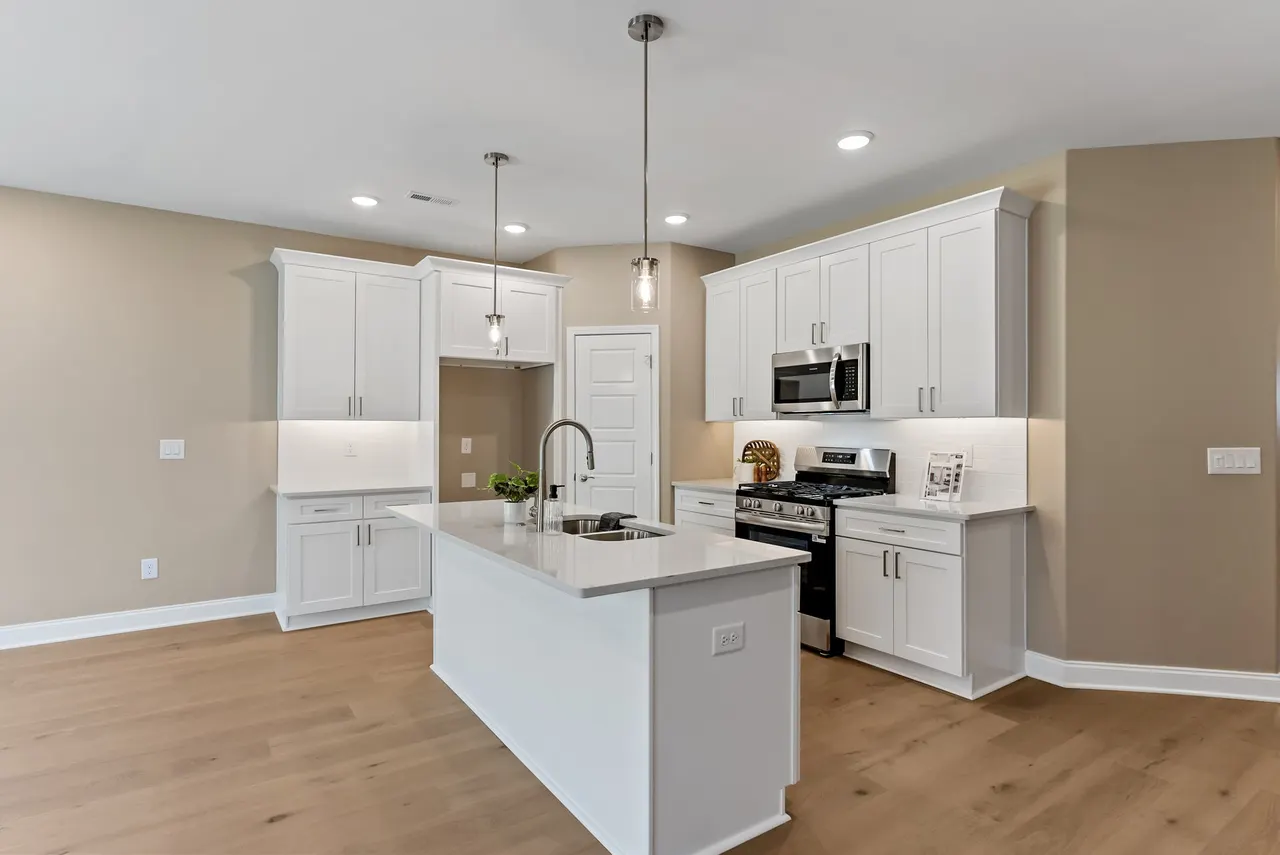 Green Meadows modern kitchen with island, white cabinets, pendant lights, and premium finishes
